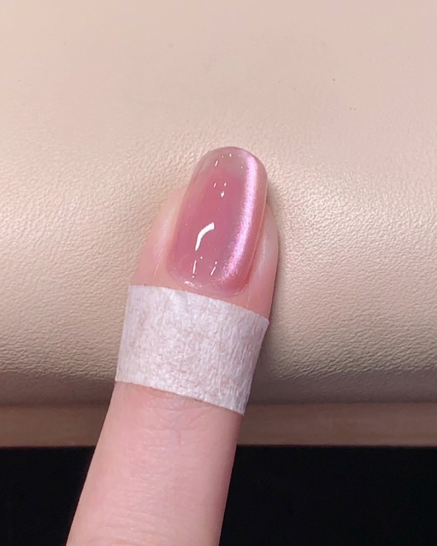 핑크 캣아이 네일 위에 투명한 탑 젤을 꼼꼼하게 바르는 모습.