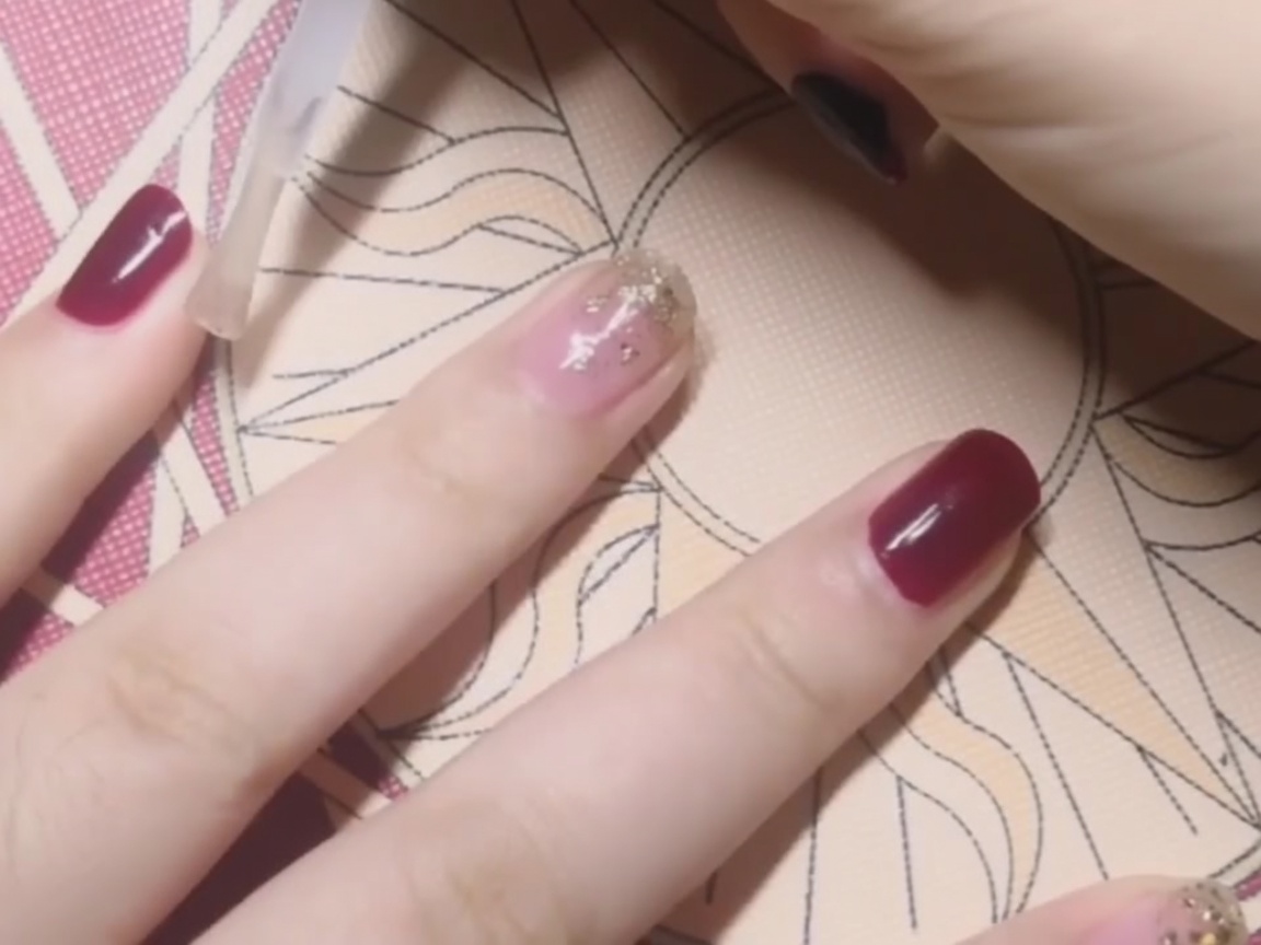 레드 컬러 손톱에 탑 코트를 바르는 모습