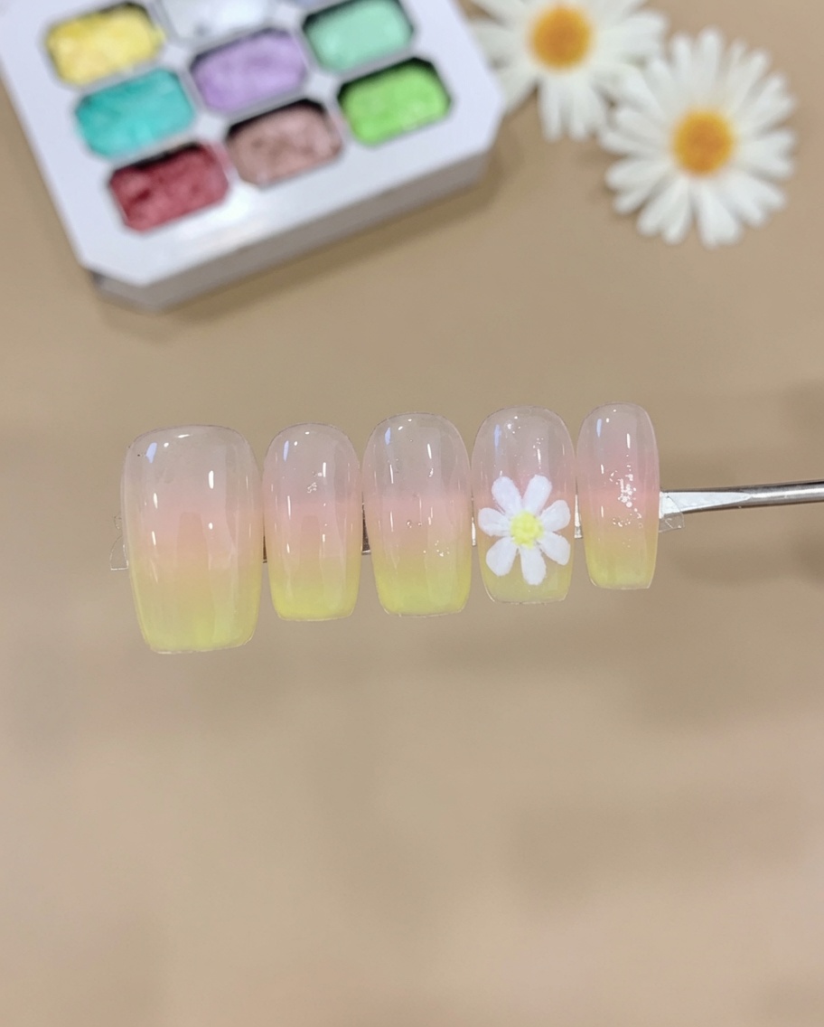 메이크업 스펀지에 핑크와 옐로우 젤을 묻혀 손톱에 톡톡 두드려 부드러운 옴브레 효과를 만드는 모습.