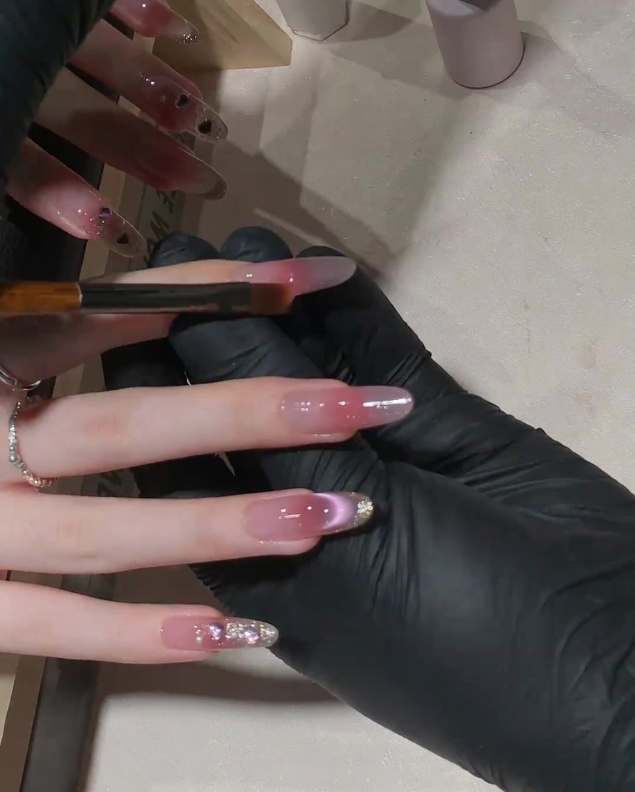 작은 평붓을 사용하여 핑크 젤을 손톱 위쪽으로 살살 펴 발라 그라데이션을 만드는 모습.