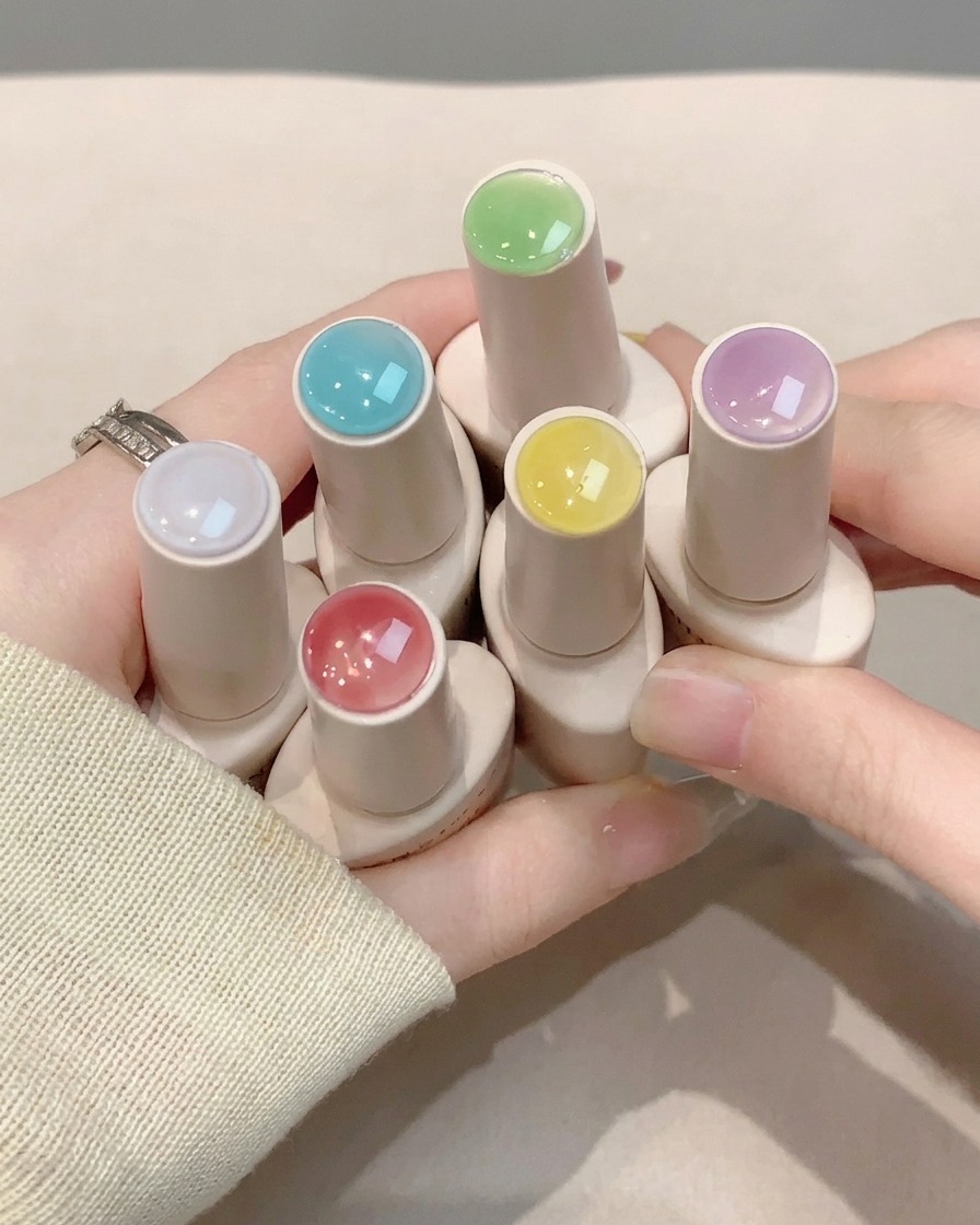 완성된 네일 아트 위에 클리어 글로시 탑 코트 층을 바르고 있는 네일 브러시.