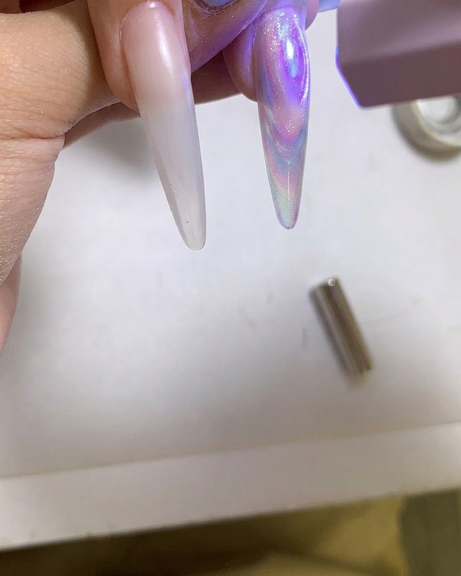 휴대용 UV/LED 램프로 광택 있는 자석젤 네일을 경화하는 모습.