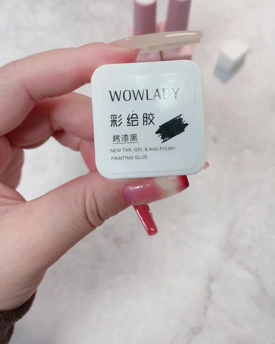 브러시가 고른 커버리지를 보장하며 준비된 손톱에 다크 레드 젤 폴리시를 바르는 모습.