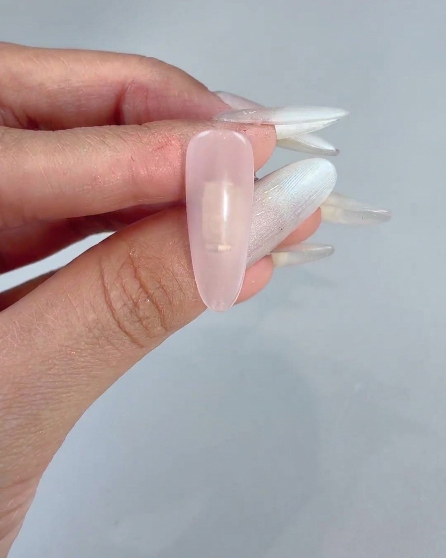 투명하게 케어된 손톱 중앙에 스펀지 블록으로 연한 핑크 젤을 톡톡 바르는 모습.