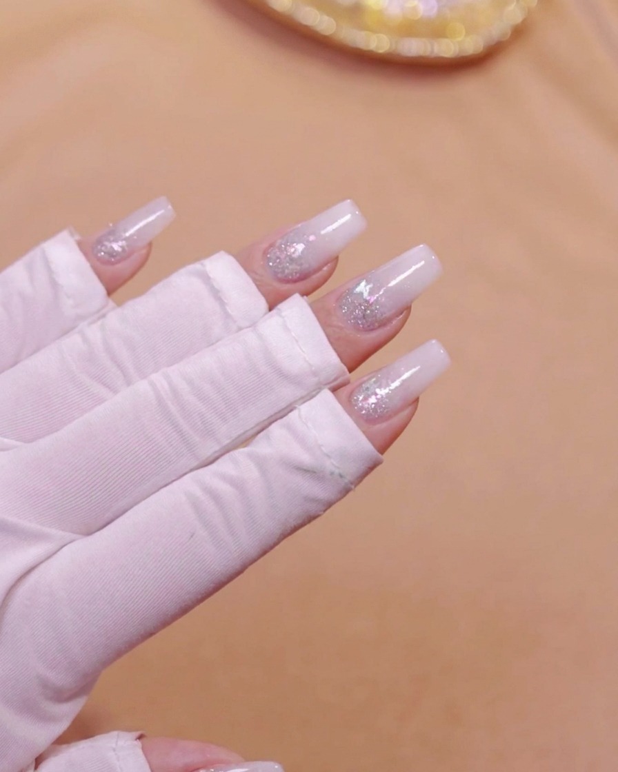 밀키 화이트 그라데이션 층을 큐어링하기 위해 UV LED 네일 램프 안에 손을 넣은 모습.