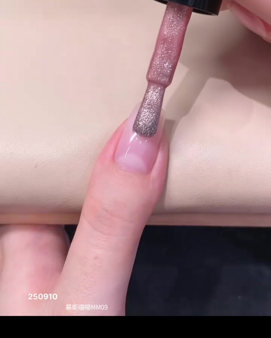 바틀 브러시로 자연스러운 손톱의 큐티클 부근에 시어 핑크 마그네틱 젤 폴리시 한 방울을 얹는 모습.