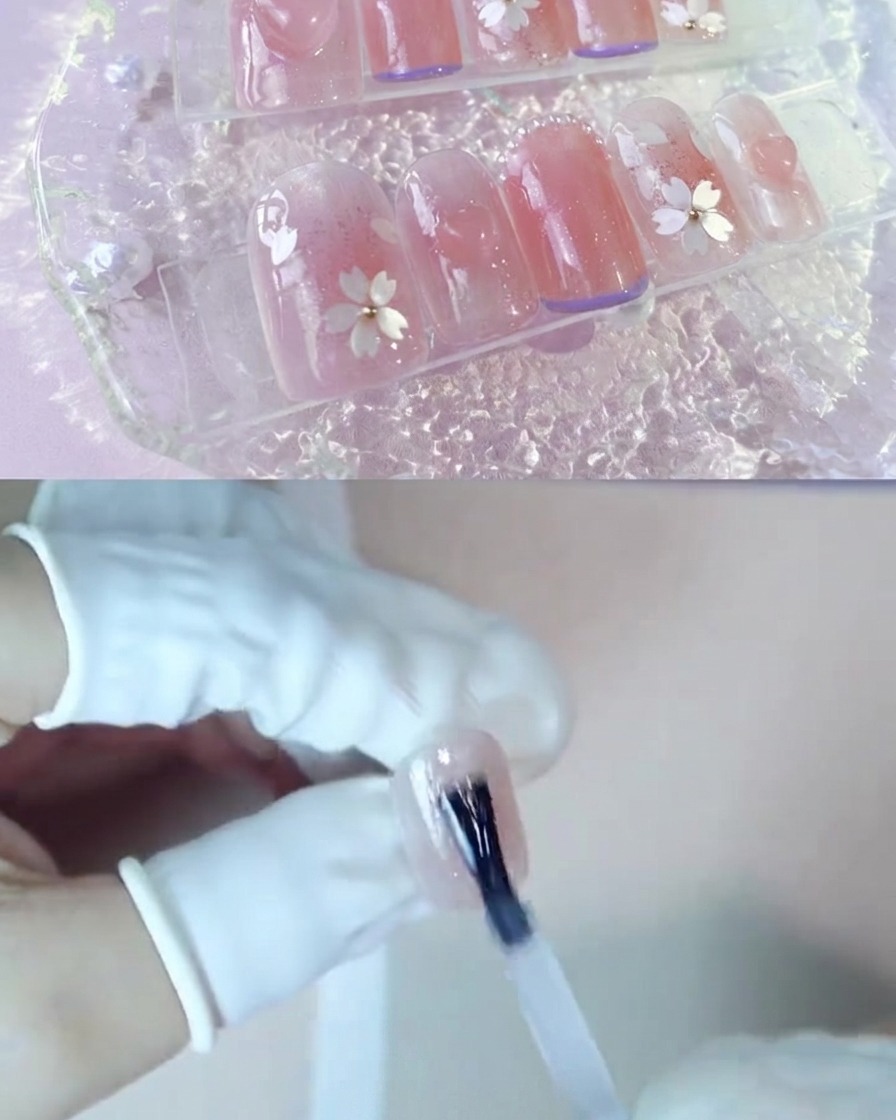 블러셔 핑크 손톱 위에 투명 강화 젤을 바르는 손.