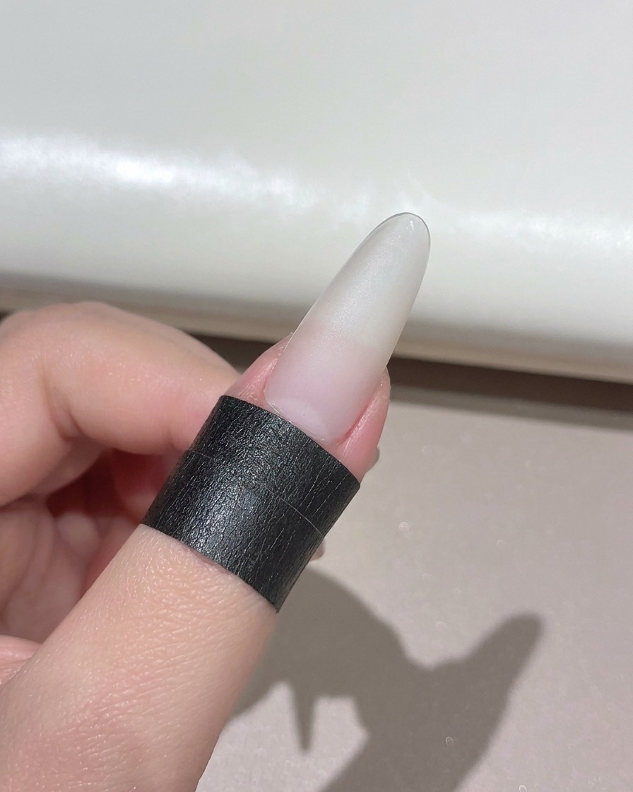 미니 핸드헬드 UV LED 램프 아래에 위치한 매니큐어 네일.