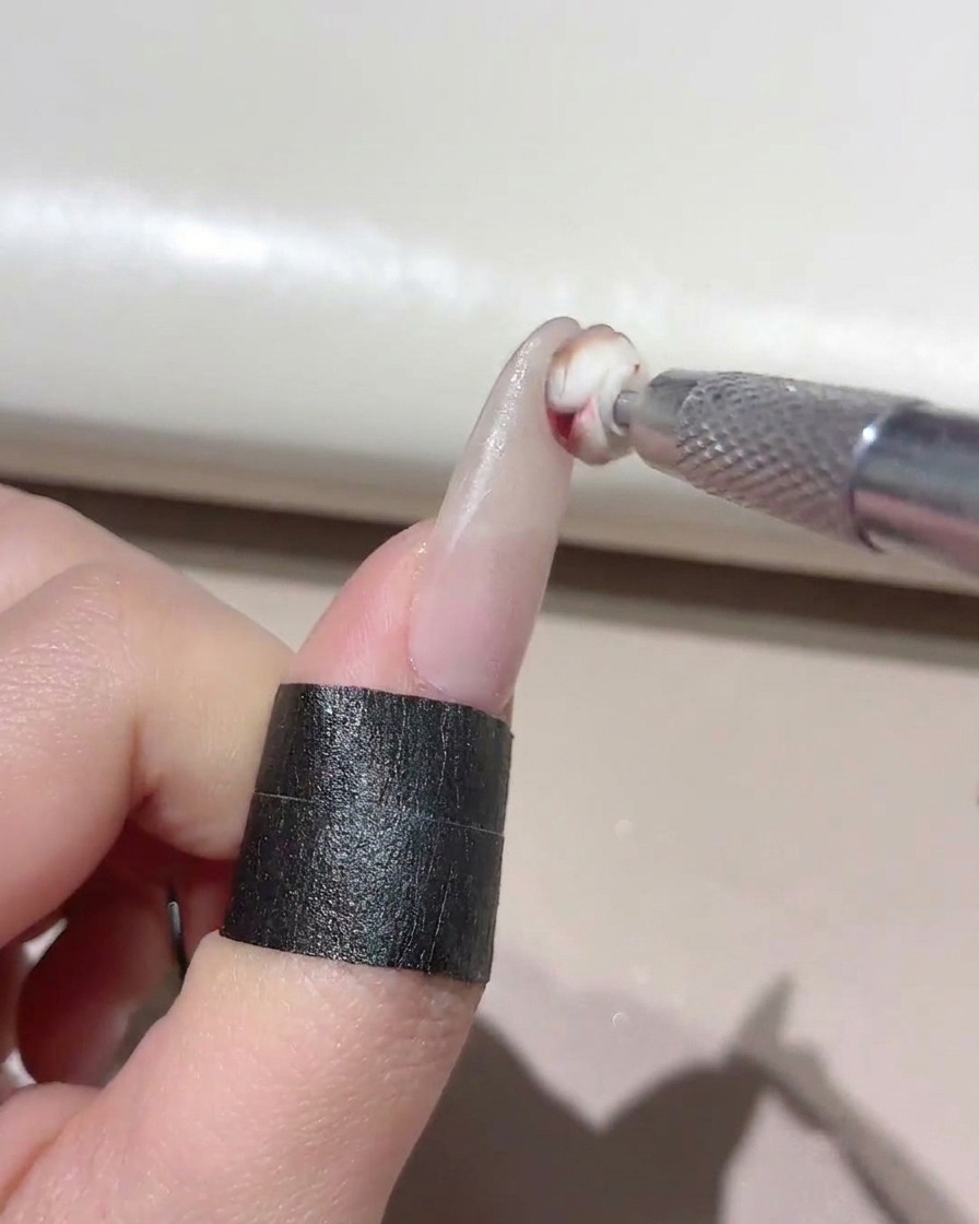 작은 스폰지 툴로 매니큐어 네일 팁에 믹스된 젤을 톡톡 두드려 바르는 모습.