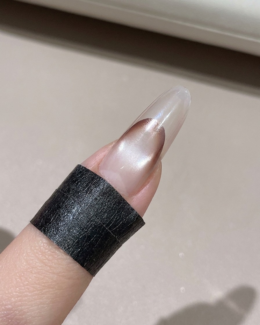 보풀 없는 천으로 장식된 네일 끝부분의 여분 젤을 닦아내는 모습.