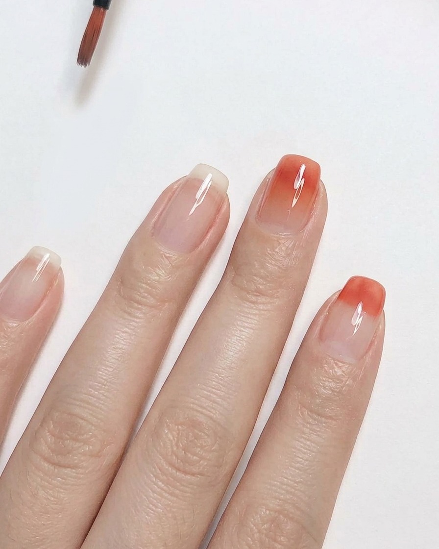 세밀한 디테일 브러시로 클리어 네일 위에 피치 핑크 젤 폴리시를 위쪽으로 블렌딩하여 부드러운 옴브레 그라데이션 효과를 만드는 모습.