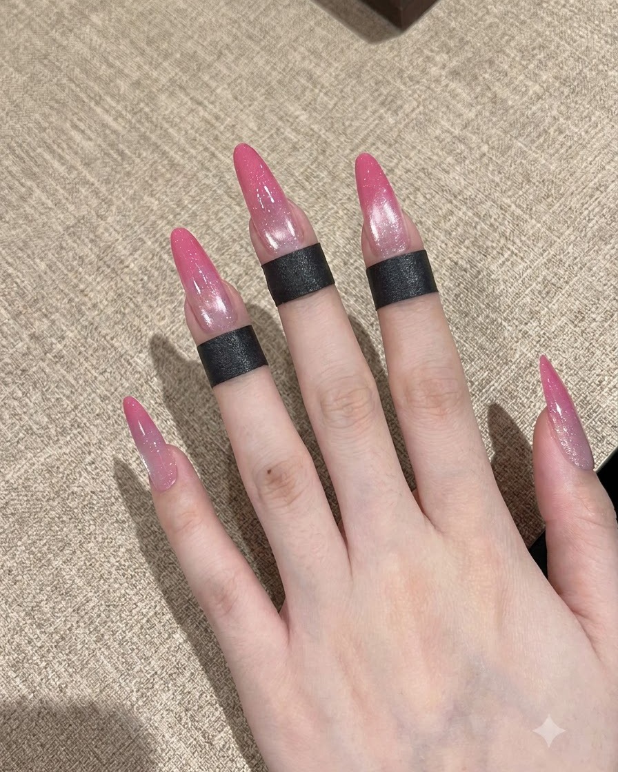 네일 브러시가 손질된 손톱 위에 투명한 베이스 코트를 바르는 모습.