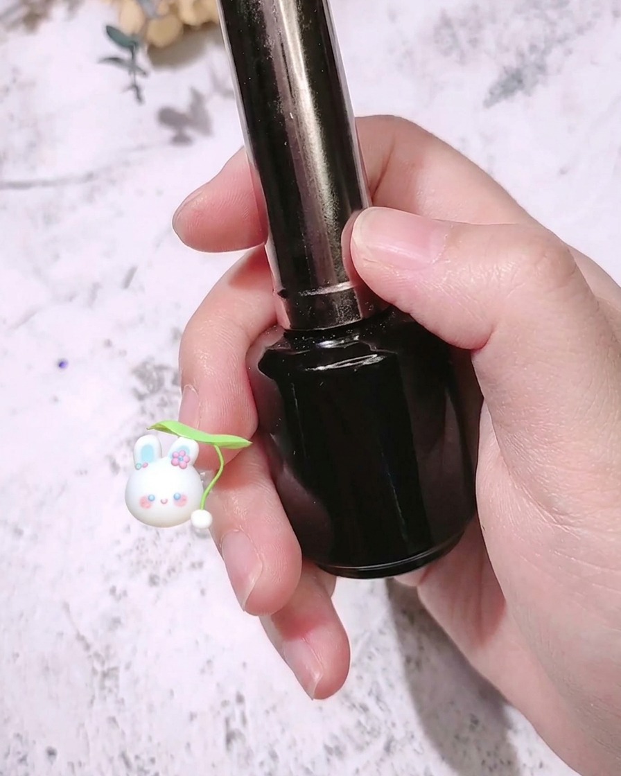선명한 로즈 레드 컬러의 손톱 위에 매트 탑 코트를 바르는 네일 브러시.