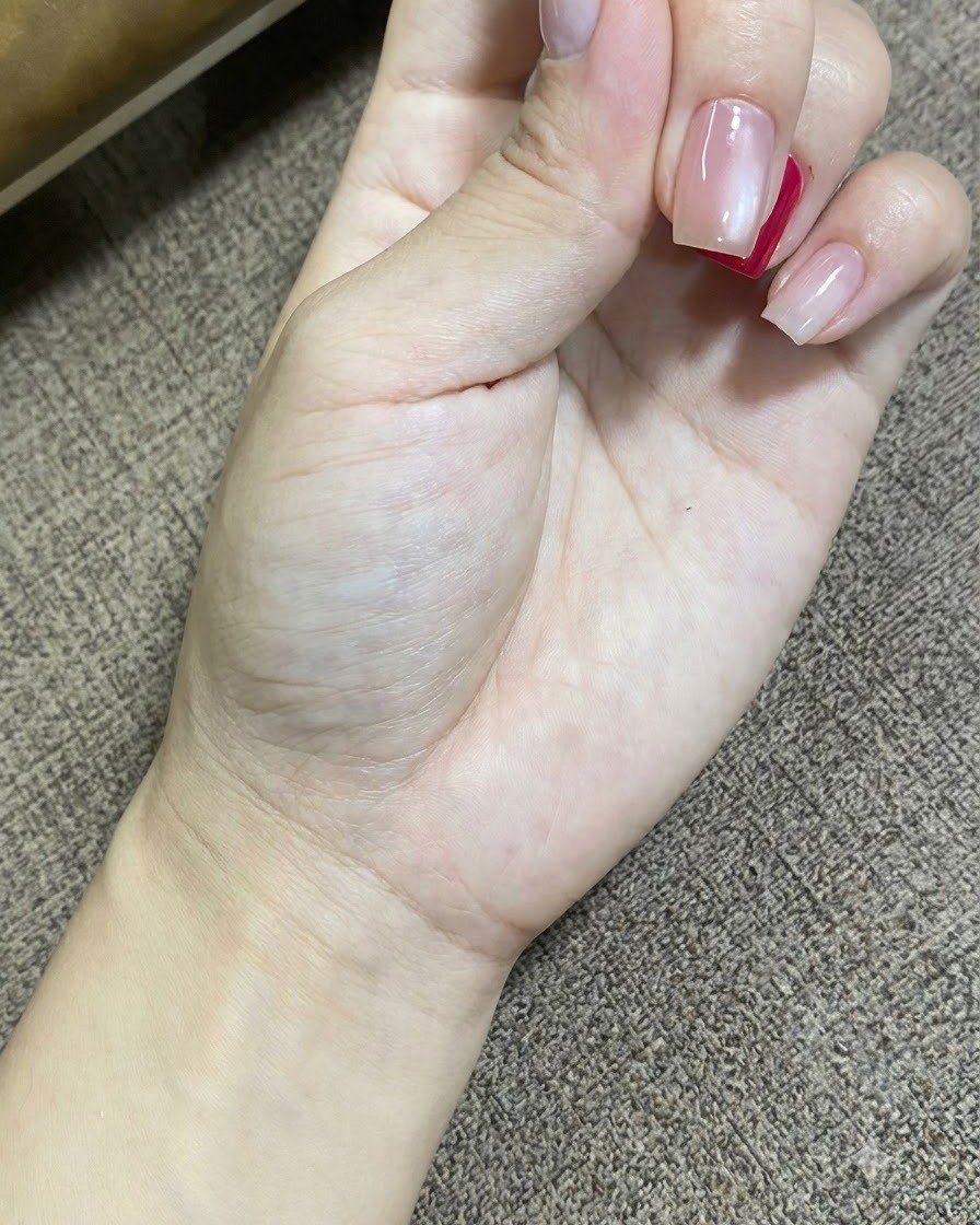 휴대용 UV LED 램프가 손톱의 젤 폴리시를 경화하는 동안 쉬고 있는 손의 클로즈업 샷.