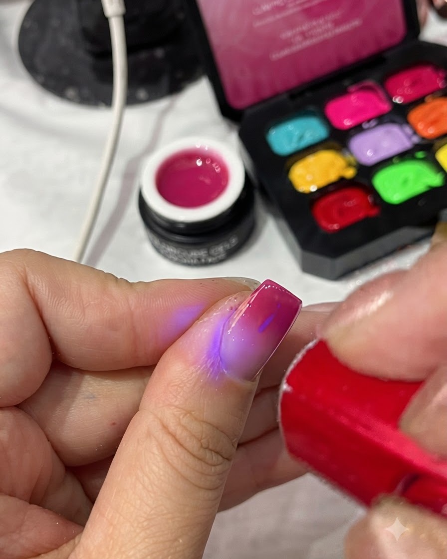 휴대용 레드 UV/LED 램프가 완성된 매니큐어의 탑 코트를 경화시키는 모습.