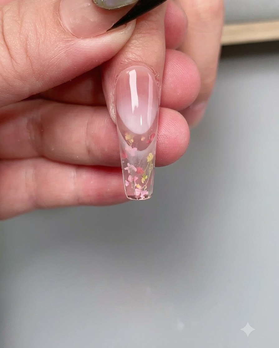 UV/LED 네일 램프의 핑크빛 광채 아래에서 네일이 큐어링되는 클로즈업 샷.