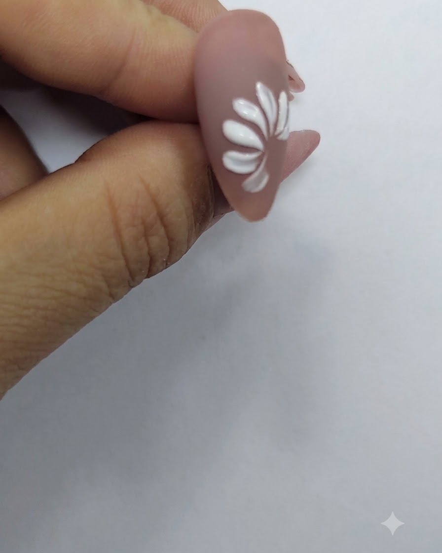누드 네일 배경 위에 전체 데이지 꽃 모양을 형성하는 완성된 화이트 꽃잎 고리.