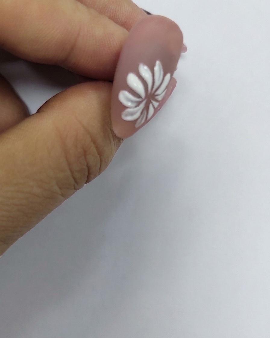 중앙에 정밀하게 배치된 작은 노란색 점이 있는, 네일에 그려진 화이트 데이지 꽃.