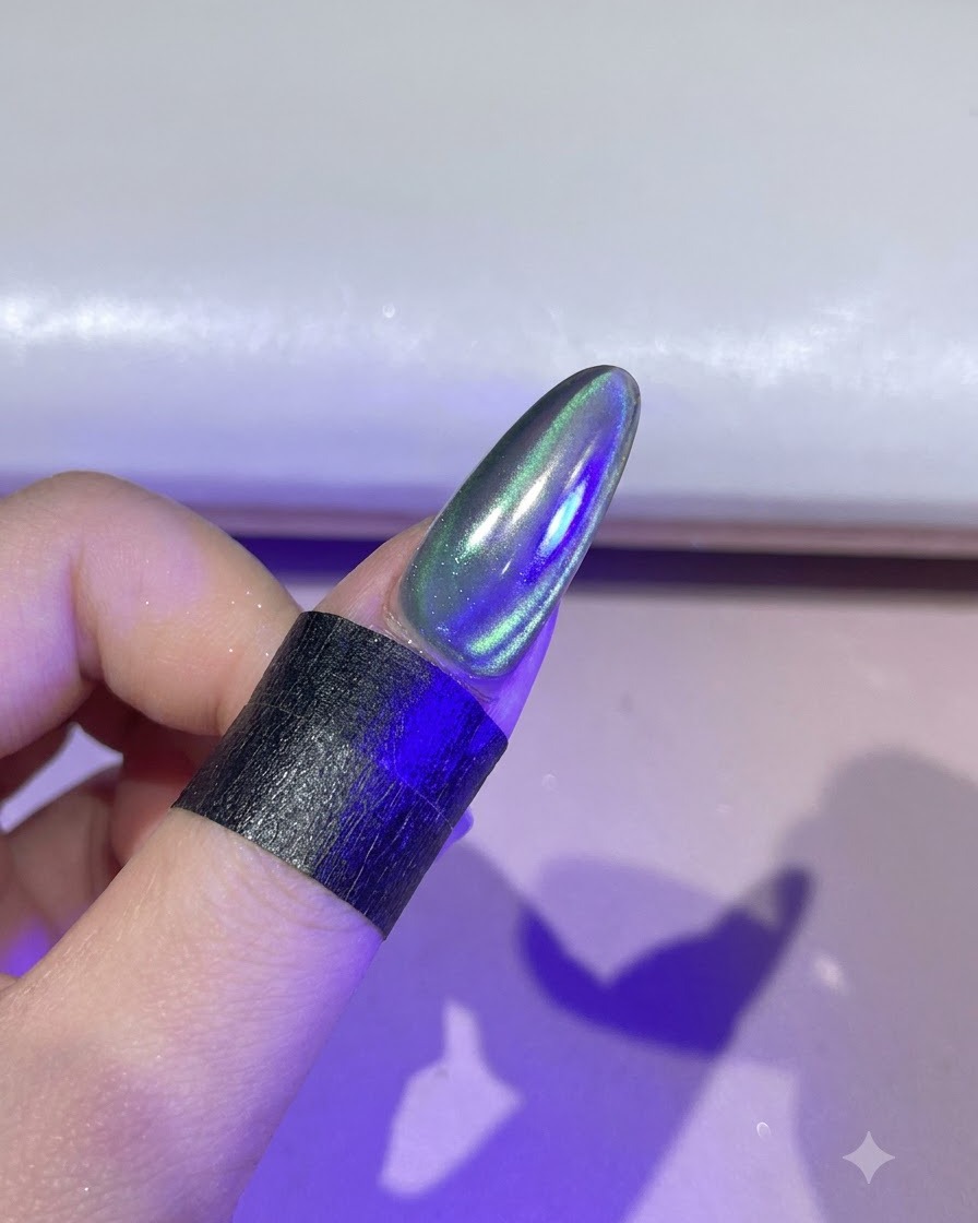 보라빛 UV/LED 경화 램프 아래에서 손톱이 빛을 받고 있는 모습.