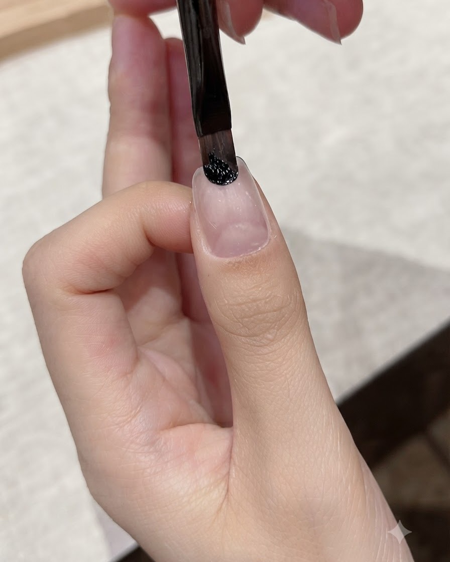 세필 라이너 브러시가 자연 손톱의 큐티클 부근에 다크 블랙 젤을 정교하게 바르는 모습.