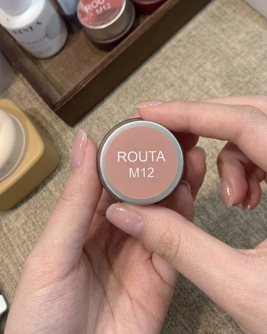 따뜻한 피치 핑크 블러시 젤 컬러가 담긴 Routa M12 라벨이 붙은 작은 자.