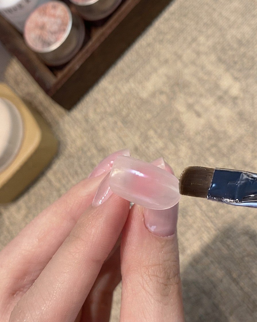 핑크빛 누드 네일의 팁 부분에 블루 쉬머 캣아이 젤을 바르는 플랫 브러시.