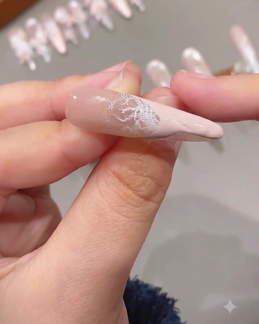 연장된 네일 위에 섬세한 화이트 레이스 오버레이와 단색 핑크 팁이 결합된 완성된 프렌치 팁.