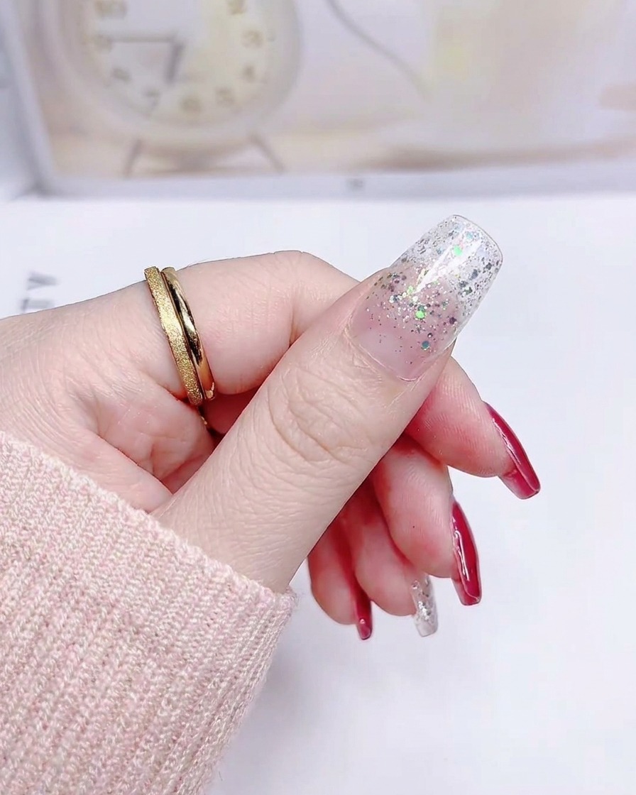 큐티클부터 팁까지 매끄럽게 부착된 실버 글리터 그라데이션 엄지손톱.