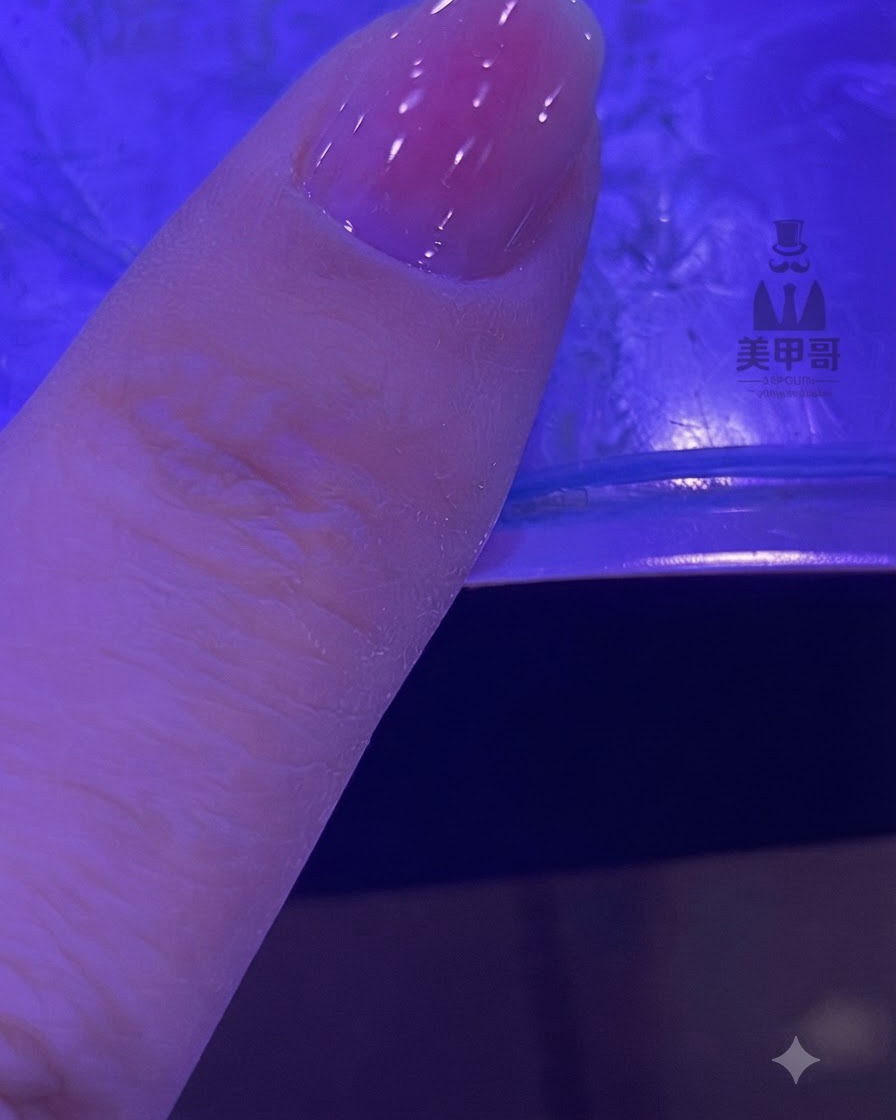 블렌딩된 핑크 그라데이션이 있는 손톱이 UV/LED 램프 아래에서 경화되는 모습.