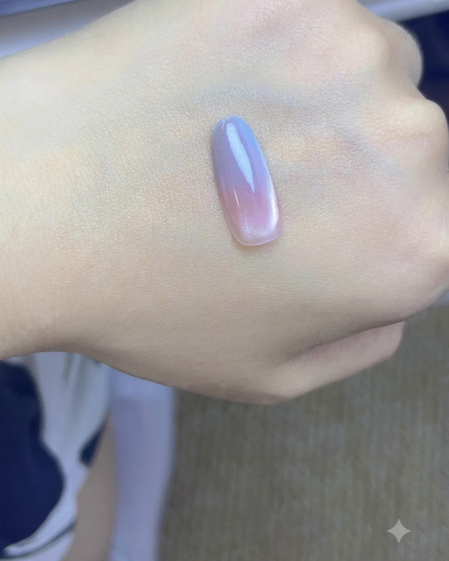 핑크와 블루 그라데이션 레이어가 적용되어 UV/LED 램프에서 경화 중인 네일 팁.