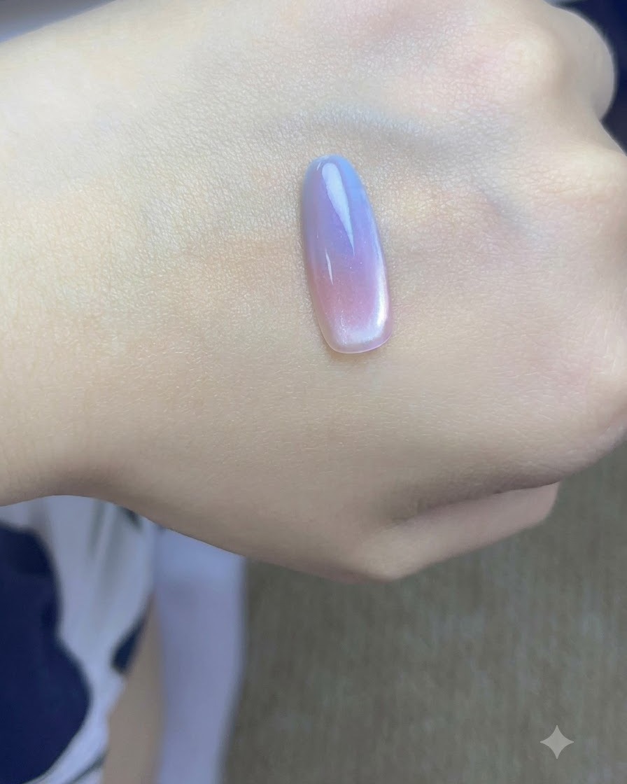 캣아이 입자를 집중시키기 위해 도포된 네일 팁 측면 가까이에 작은 자석을 대고 있는 모습.