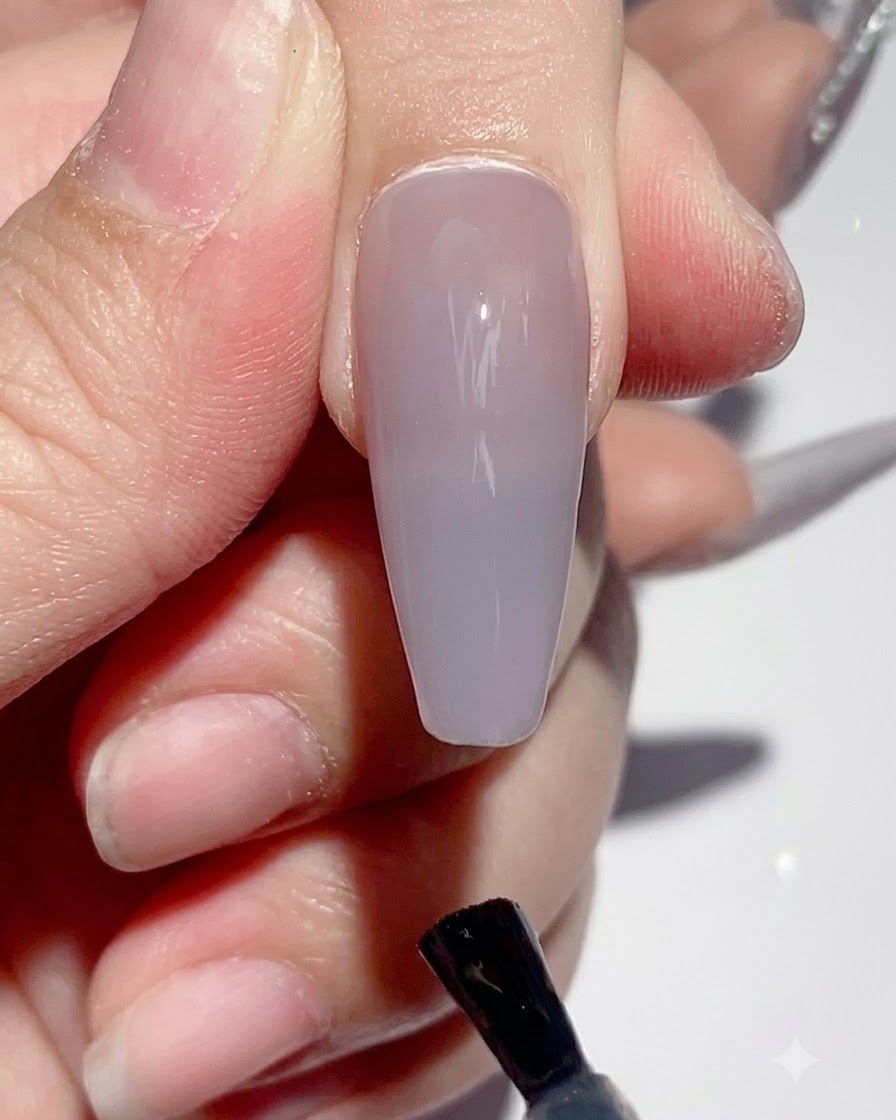 큐어링 과정 중 UV LED 네일 램프 아래에 손을 넣고 있는 모습.
