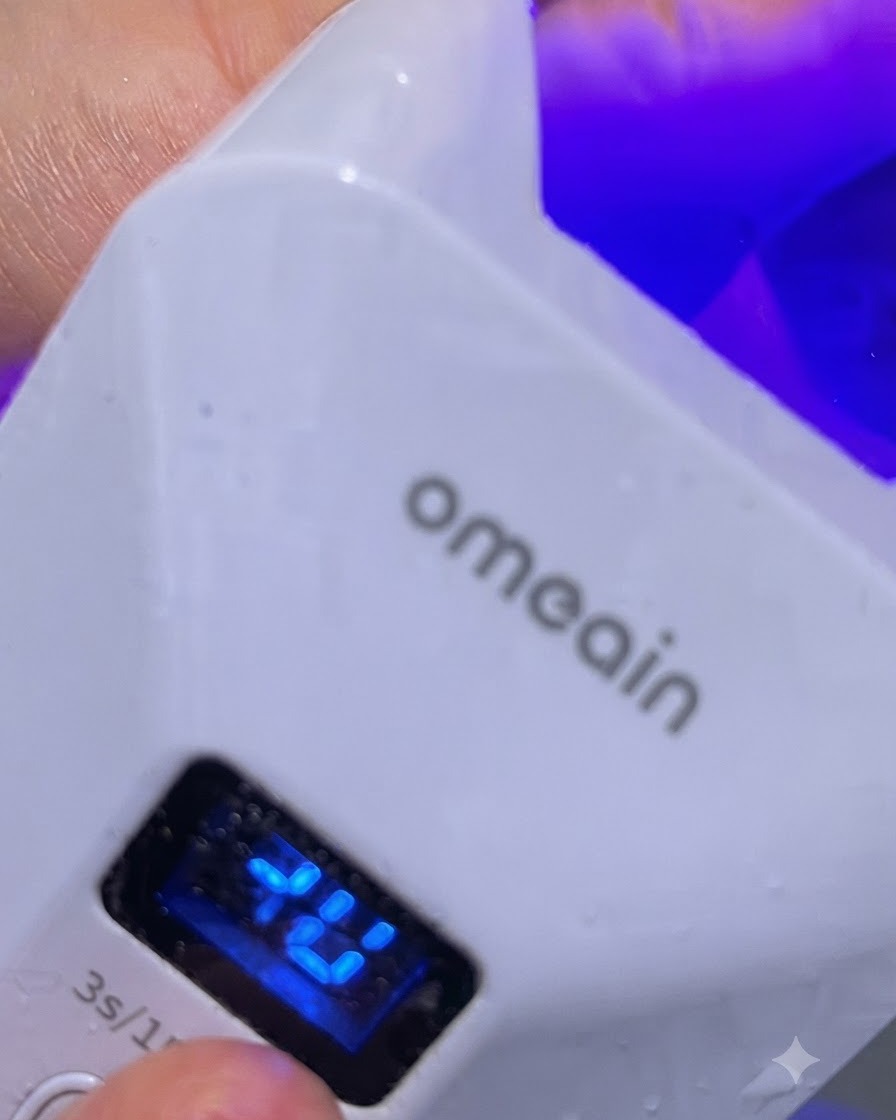 Eine kleine LED-Lampe beleuchtet einen einzelnen Finger während einer kurzen Aushärtung.
