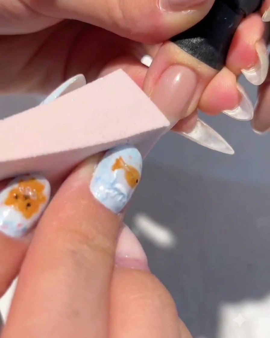 Ein Make-up-Schwämmchen tupft weißes Gel auf die Nagelspitze, um einen Farbverlauf zu bilden.