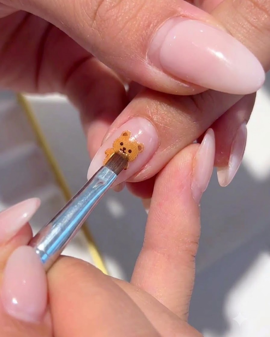 Ein feiner Pinsel platziert schimmernde Glitzerflocken um das gemalte Blumen-Nail-Art.