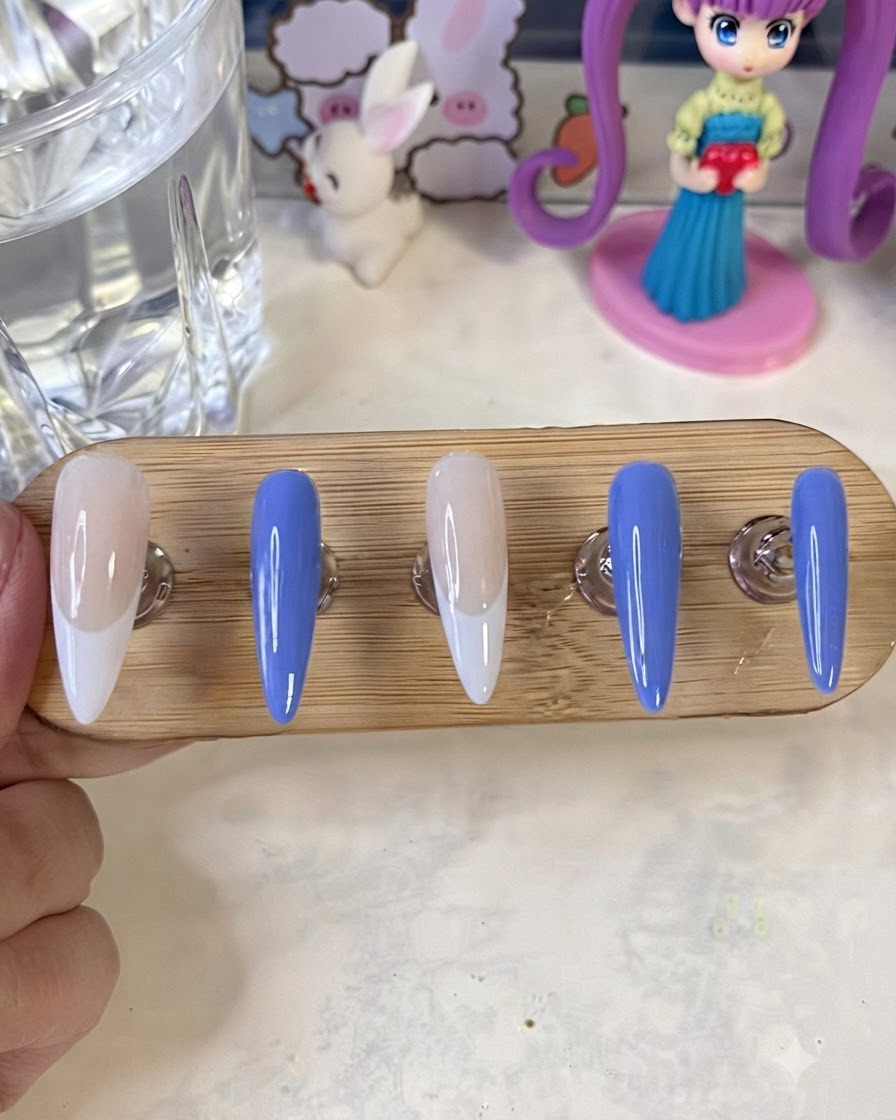 완성된 채색 네일이 있는 네일 스탠드가 UV/LED 큐어링 램프 아래에 놓인 모습.