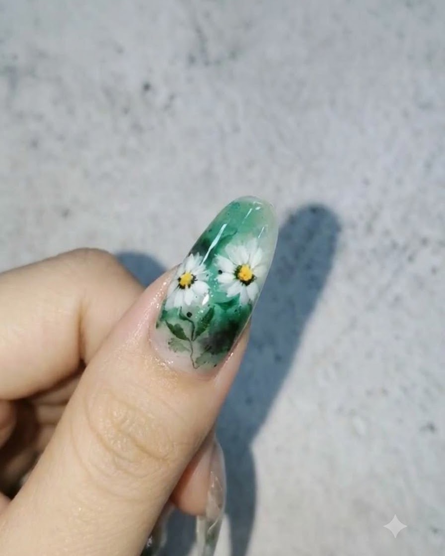화이트 데이지와 잎사귀, 그리고 표면의 광택 있는 3D 물방울 포인트가 어우러진 완성된 네일 디자인.