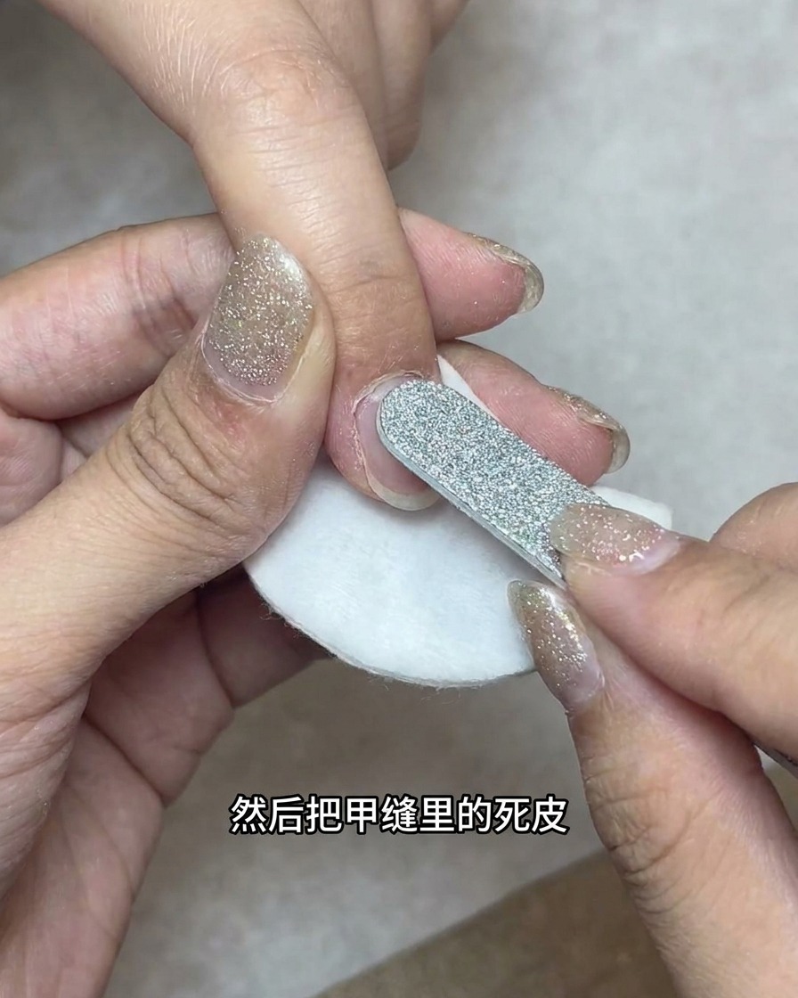 화장솜 위에서 불릿 형태의 네일드릴 비트가 사이드 네일 그루브를 청소하는 모습.