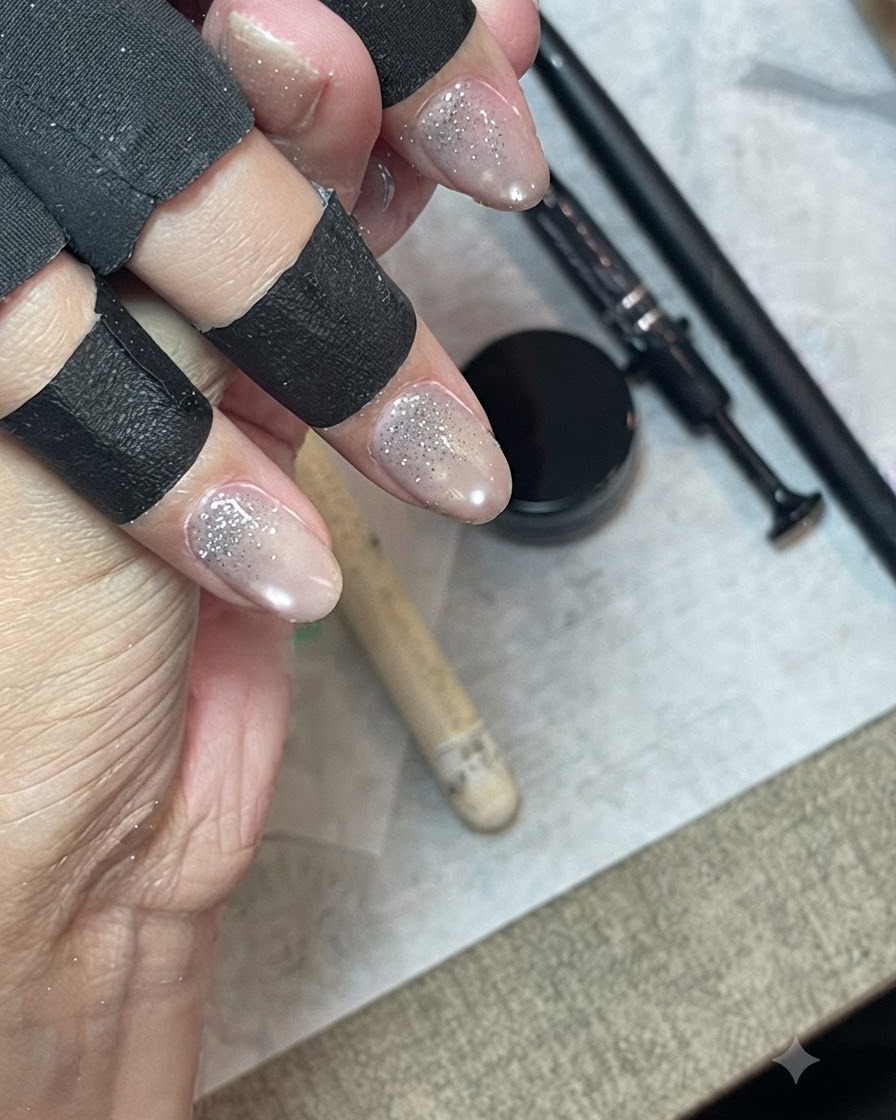 검은색 손가락 보호대를 착용한 손이 파인 라이너 브러시로 글리터 젤을 가볍게 쓸어내리며 블렌딩하는 모습.