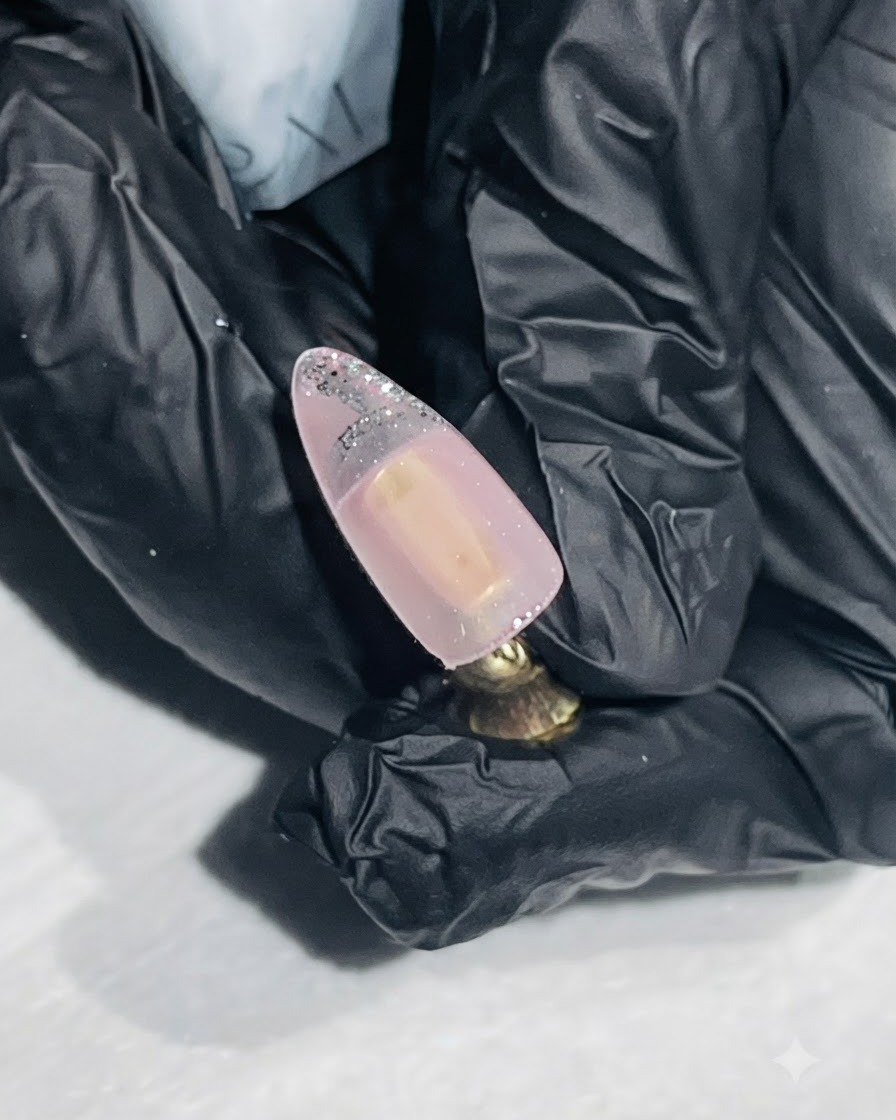 누드 컬러 네일의 팁에 실버 아웃라인을 그리고 있는 파인 라이너 브러시.