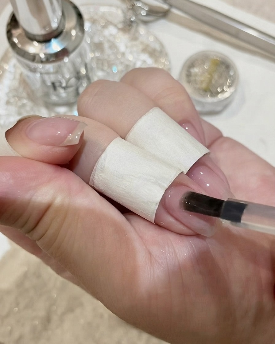 커다란 크리스탈 젬스톤이 얹어진 손톱이 UV 램프 아래에서 큐어링되는 모습.