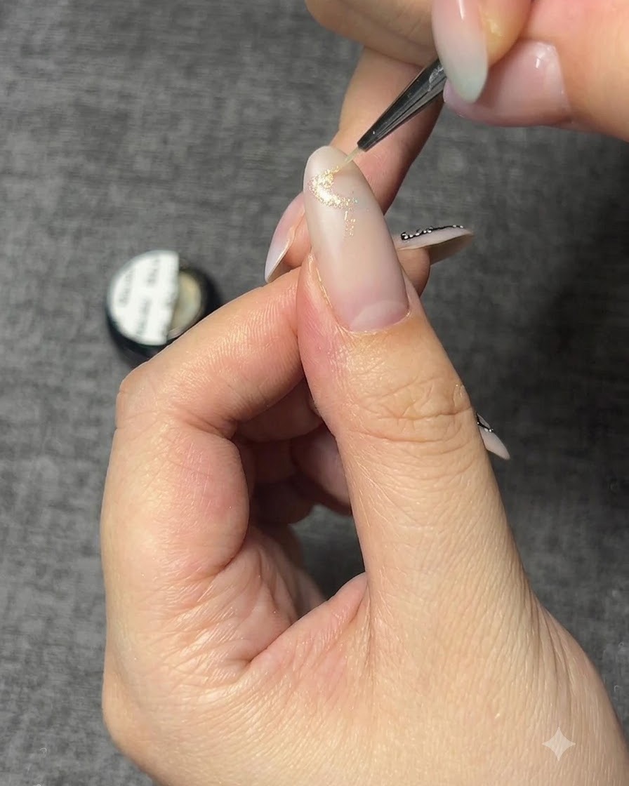 스파클 젤로 나비 베이스 아웃라인이 그려진 손톱의 클로즈업 샷.