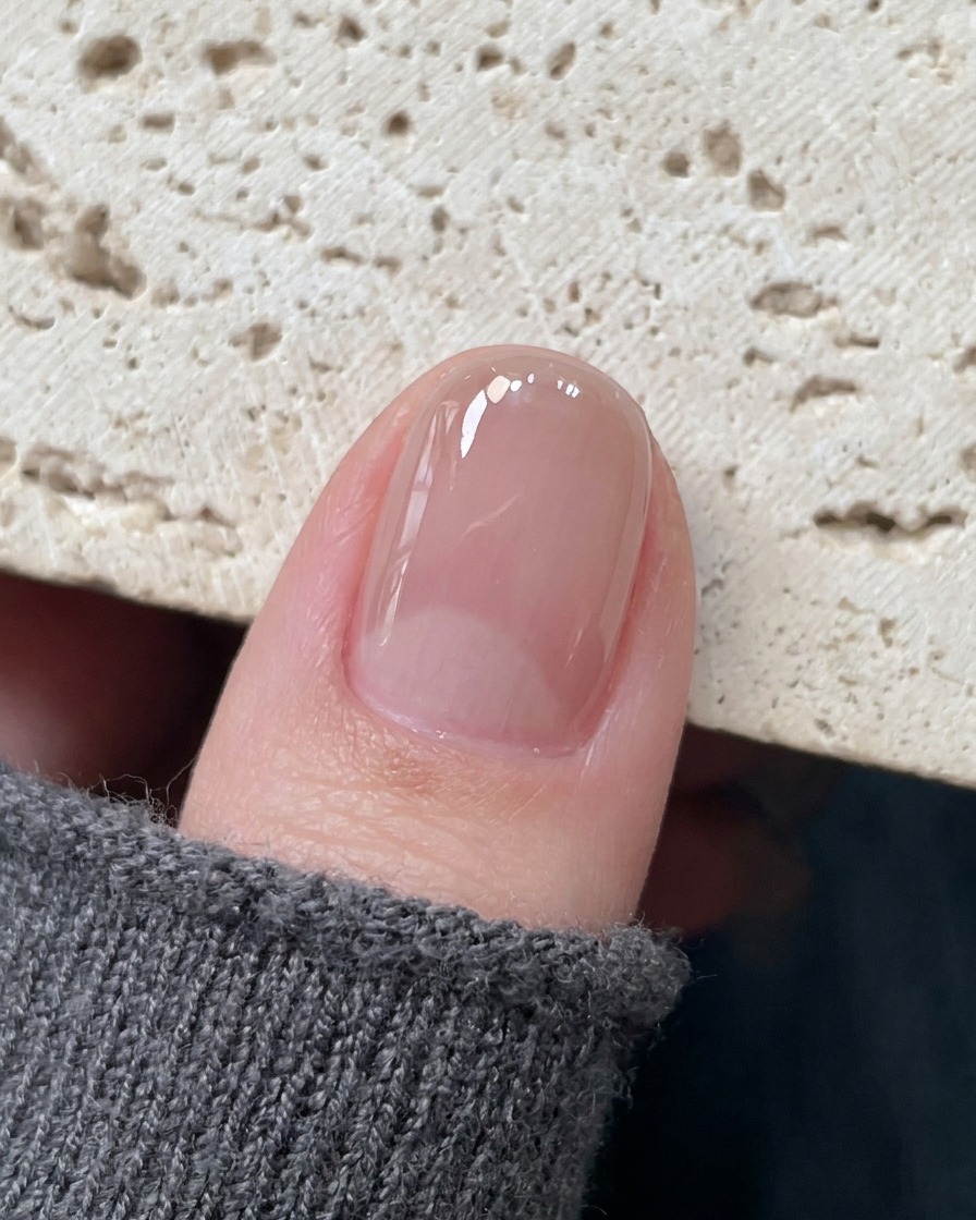 정밀 핀셋이 경화된 손톱 중앙에 섬세한 홀로 스타 스티커를 올리는 모습.