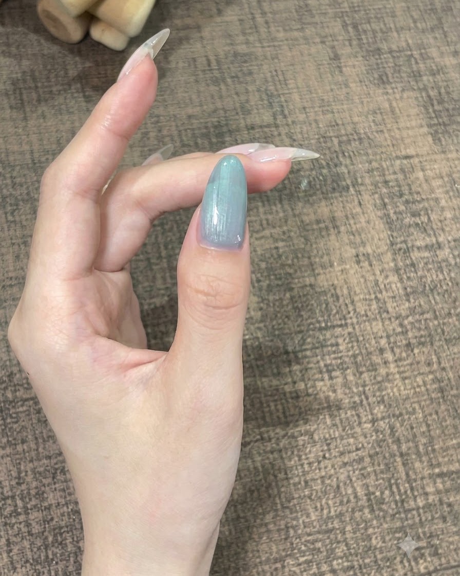 부드러운 곡선으로 자리 잡기 위해 가만히 고정된 셀프 레벨링 젤이 있는 단일 손가락의 클로즈업.
