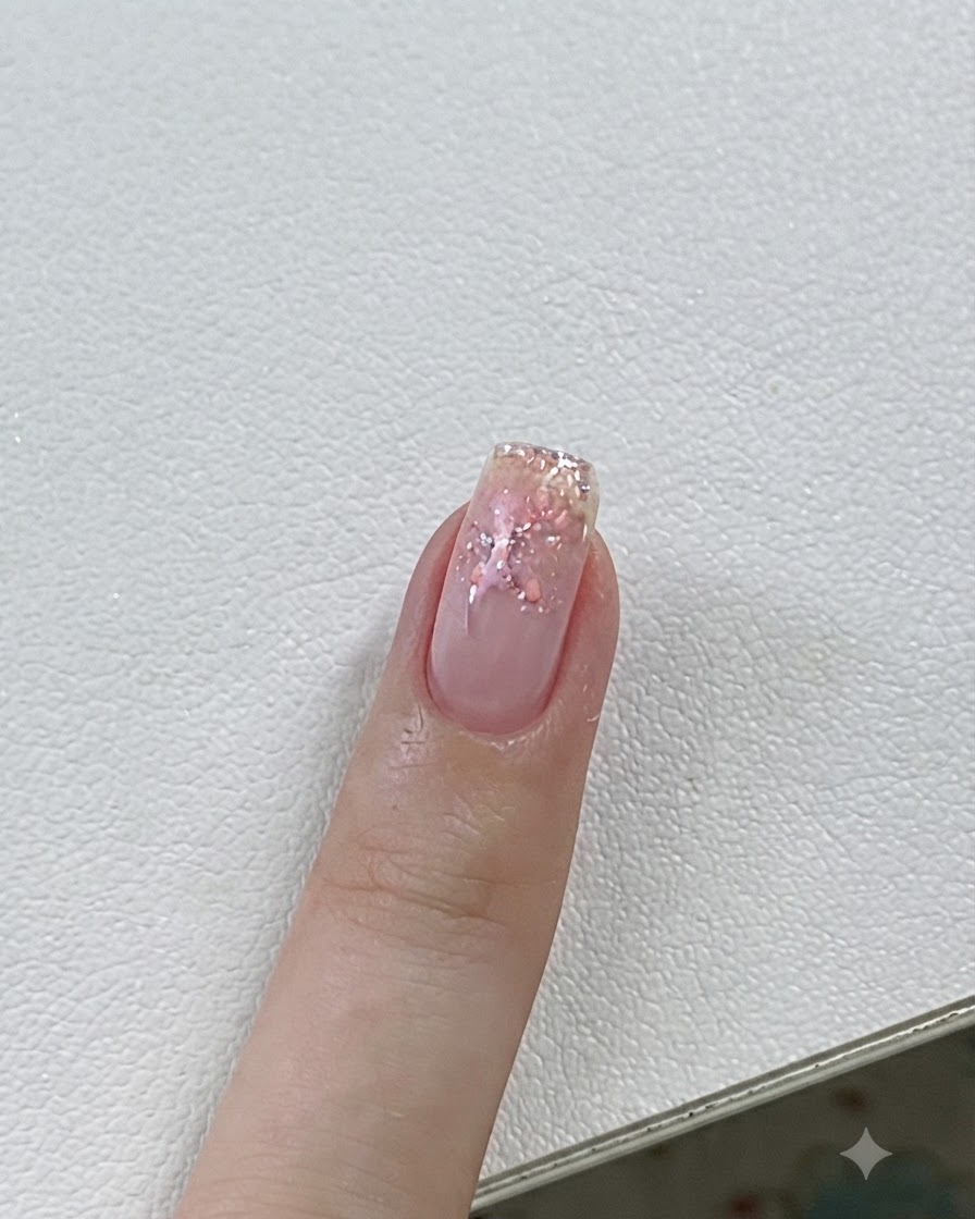 핑크 젤과 별 아트가 완성된 손톱을 UV/LED 램프로 큐어링하는 클로즈업.