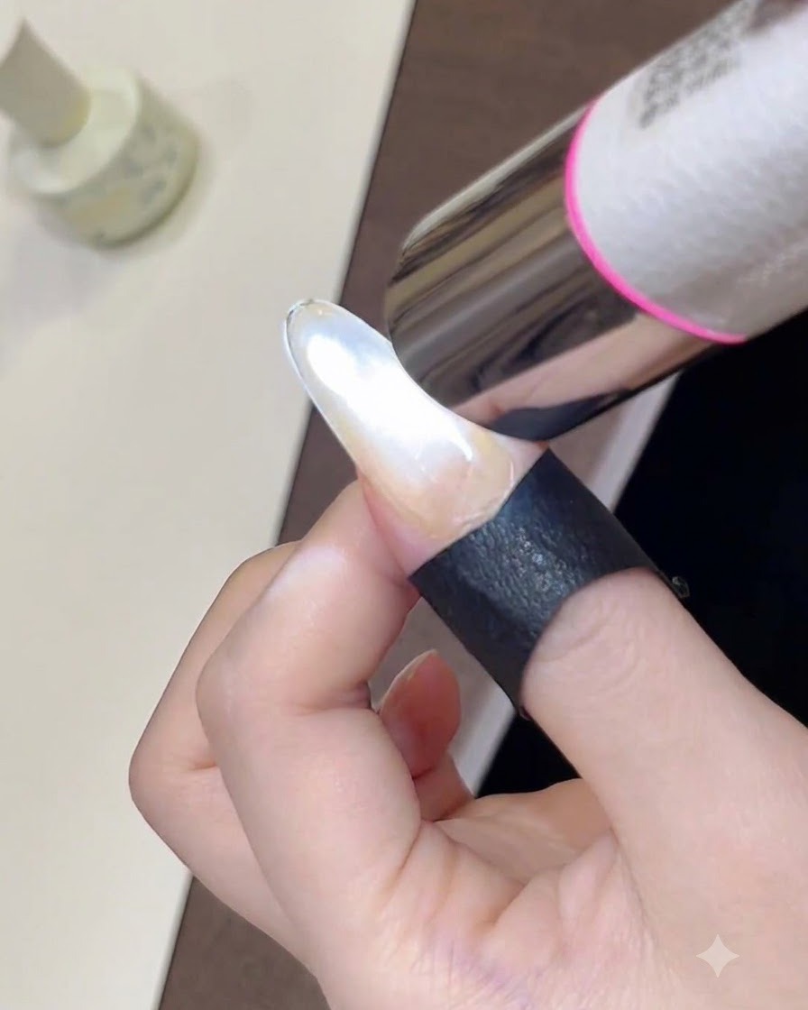 휴대용 미니 UV 램프로 방금 스타일링한 반짝이는 캣아이 젤 폴리시를 경화시키는 클로즈업 샷.