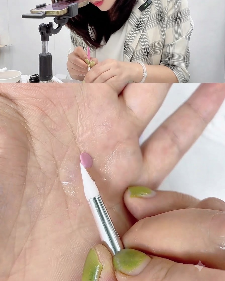 손바닥 위에 놓인 작은 핑크 젤 디스크의 가장자리를 화이트 실리콘 카빙 펜이 터치하며 말아 올리는 모습.