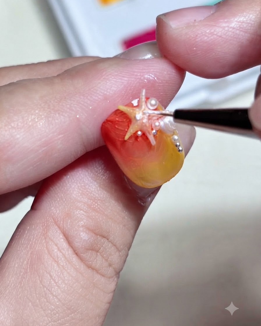세밀한 브러시가 그라데이션 네일에 장착된 3D 불가사리 파츠 표면에 디테일한 화이트 도트와 하이라이트를 더하는 모습.