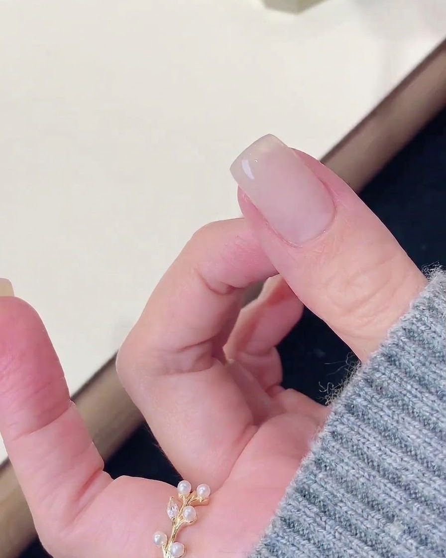 네일 램프에서 큐어링을 마친 손가락을 클렌저 패드로 닦아내는 모습.