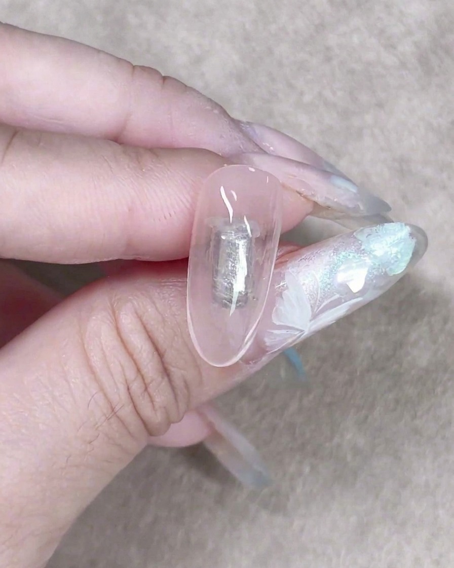 작은 메이크업 스펀지가 부드러운 질감의 배경을 만들기 위해 손톱에 셰어 밀키 젤을 가볍게 두드려 바르는 모습.